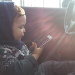 A child holds a cellphone, the kind of device a parent supervises with Google Family Link.