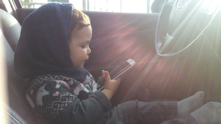 A child holds a cellphone, the kind of device a parent supervises with Google Family Link.