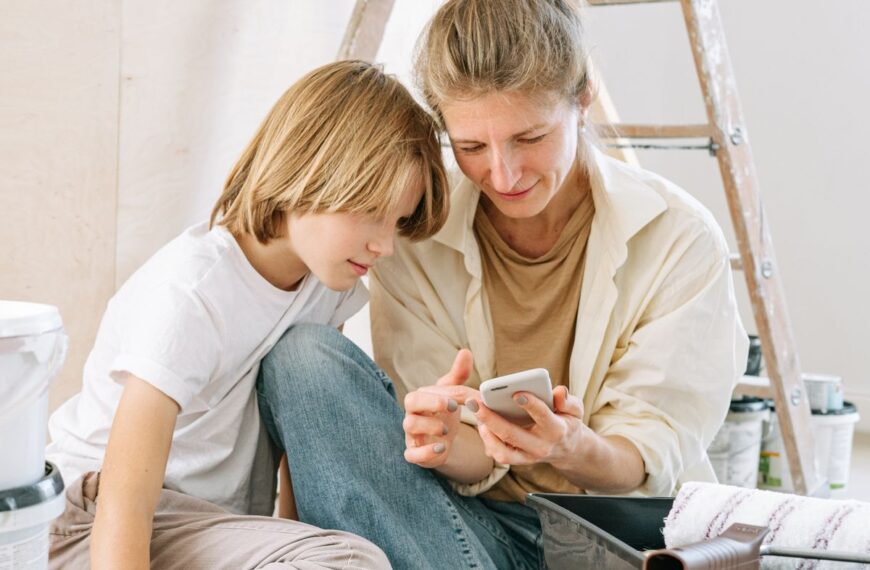A parent and child look at a smartphone together.